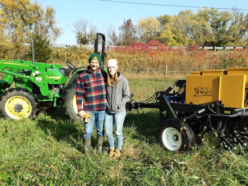 Farmers pose with tractor and no-till drill