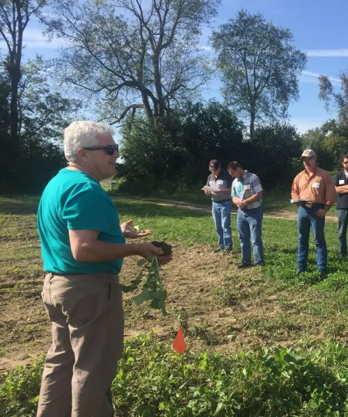 An adult conducting a training for several other people lined up to watch.