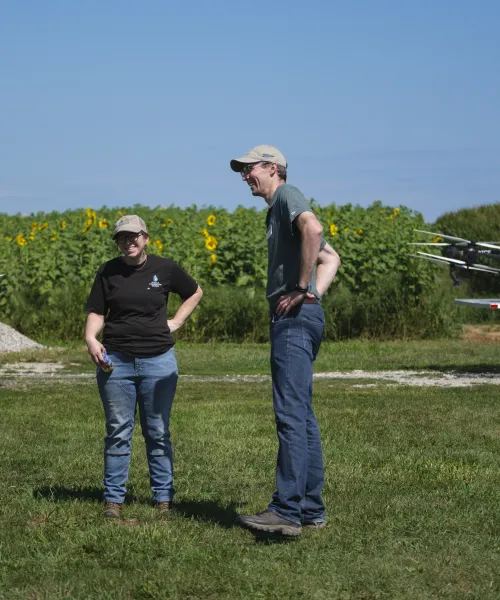 conservation district staff with a drone and sunflowers