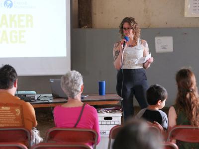 Person on microphone presenting at Speaker Stage (Photo Credit: Paul Michael Peters)