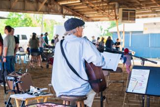 Man playing guitar at native plant expo