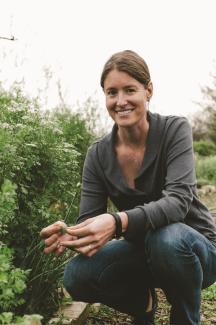 woman crouching by native plants