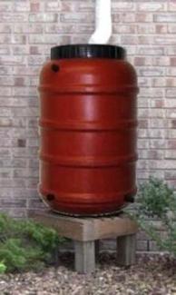 Terra-cotta Rain Barrel on pedestal riser stand with downspout to top