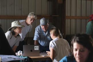 farmers gathering near a computer