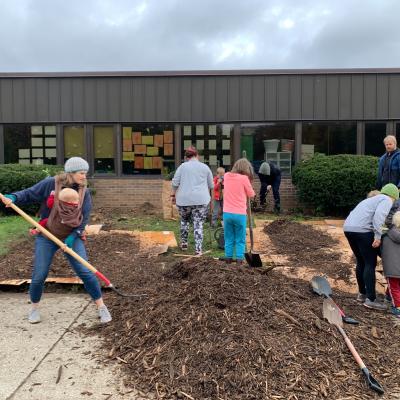 Teachers, parents, and students working on a native plant garden. 