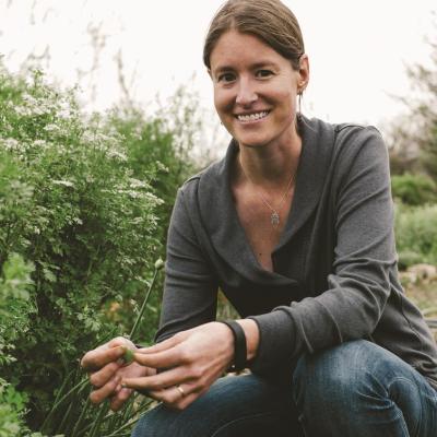woman crouching by native plants