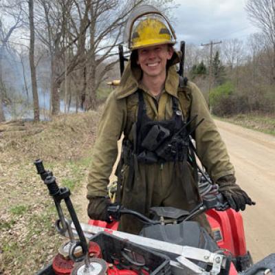 Plantwise staff managing a prescribed burn with torches and quad vehicles.